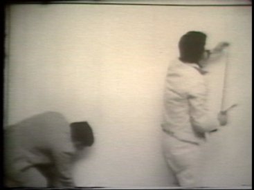 Still from Sequence 15 of Idea Demonstrations. Peter Kennedy and Mike Parr mark the periphery of the camera image.