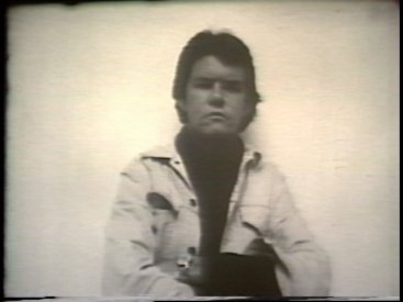 Still from Sequence 8 of Idea Demonstrations. Peter Kennedy attempts to form an after image of the camera and camera operator on his retinas.